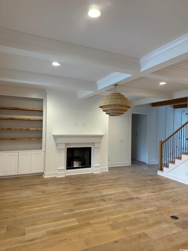 unfurnished living room with beam ceiling, light hardwood / wood-style flooring, coffered ceiling, and crown molding