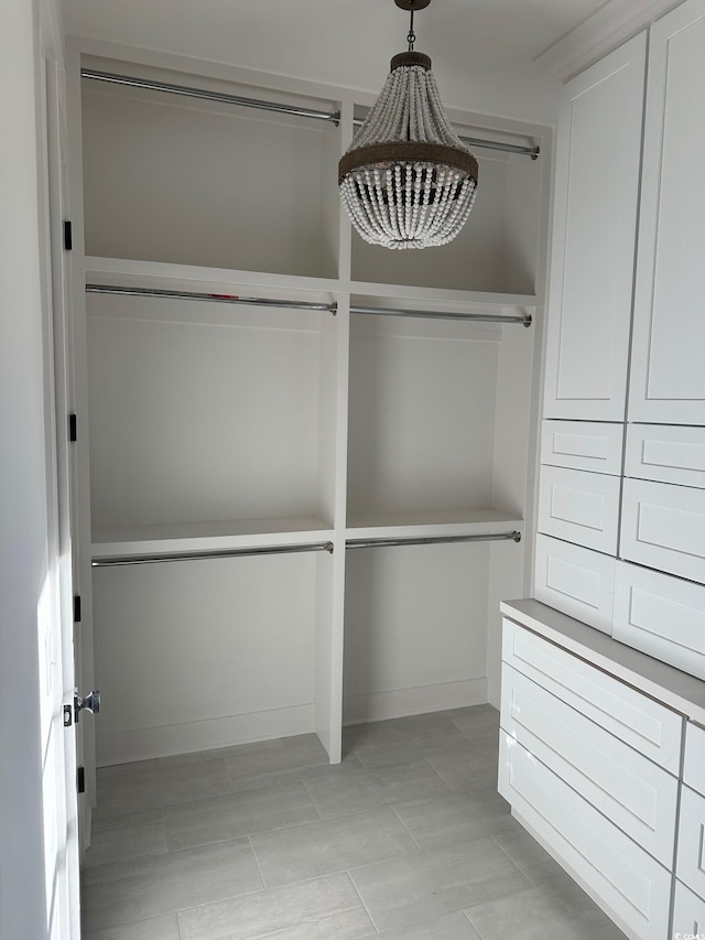 spacious closet featuring a chandelier