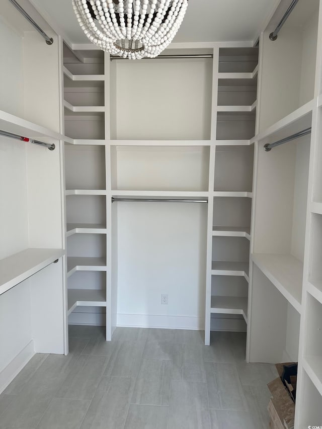 walk in closet with a chandelier