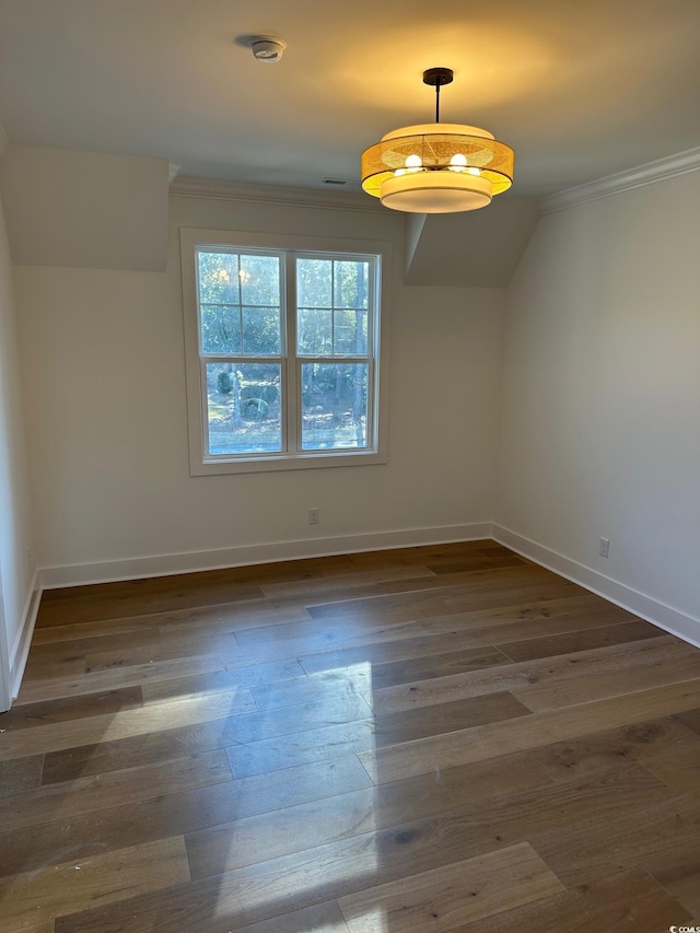 unfurnished dining area with crown molding and dark wood-type flooring