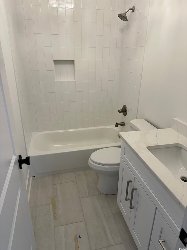 full bathroom featuring toilet, vanity, and tiled shower / bath