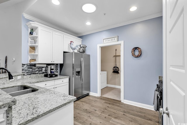 kitchen with stainless steel fridge, light stone countertops, and white cabinetry