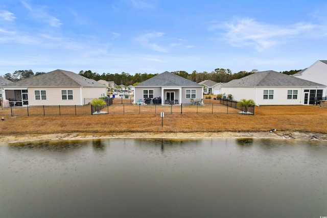 back of house featuring a yard and a water view