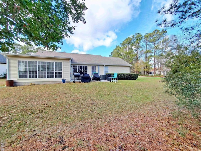 rear view of house featuring a lawn and a patio area