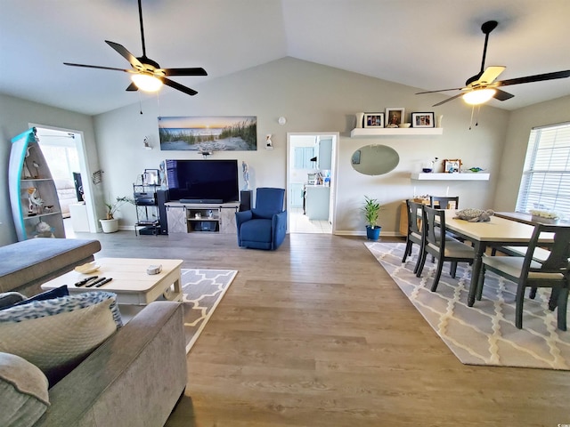 living room featuring vaulted ceiling, plenty of natural light, and wood-type flooring