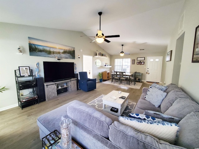 living room featuring light wood-type flooring, ceiling fan, and vaulted ceiling