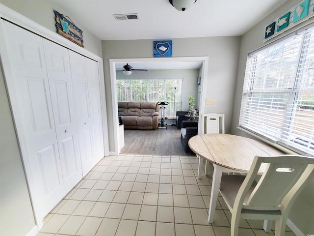 tiled dining space with ceiling fan