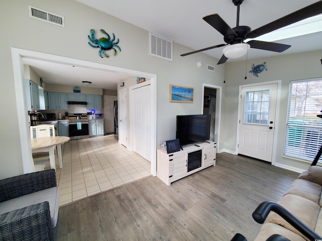 living room featuring ceiling fan and light hardwood / wood-style floors