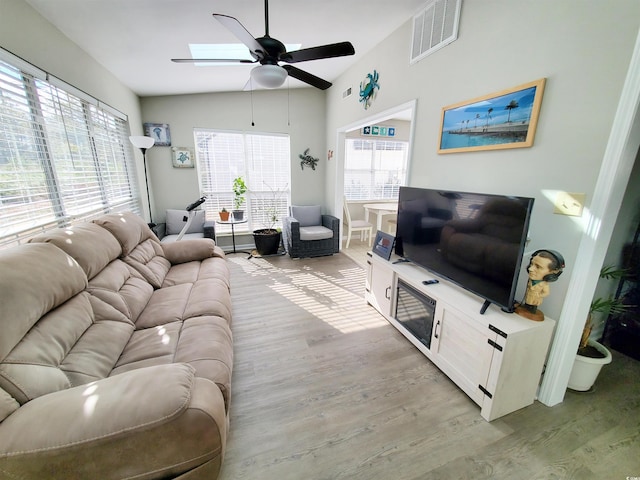 living room featuring ceiling fan, light wood-type flooring, and lofted ceiling