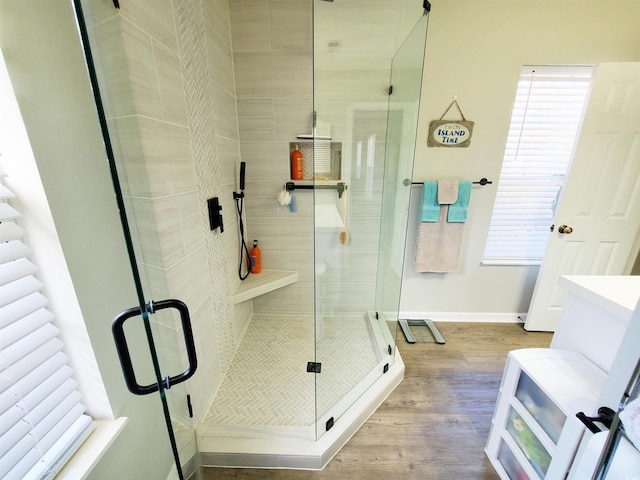 bathroom featuring a shower with shower door and hardwood / wood-style flooring