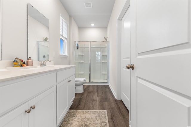 bathroom featuring hardwood / wood-style floors, vanity, toilet, and walk in shower