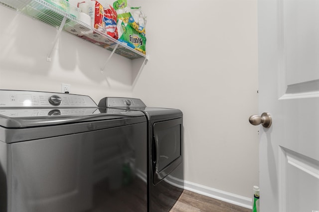 clothes washing area with dark hardwood / wood-style flooring and independent washer and dryer