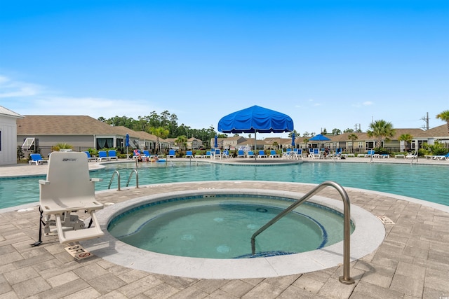 view of swimming pool featuring a patio area and a hot tub