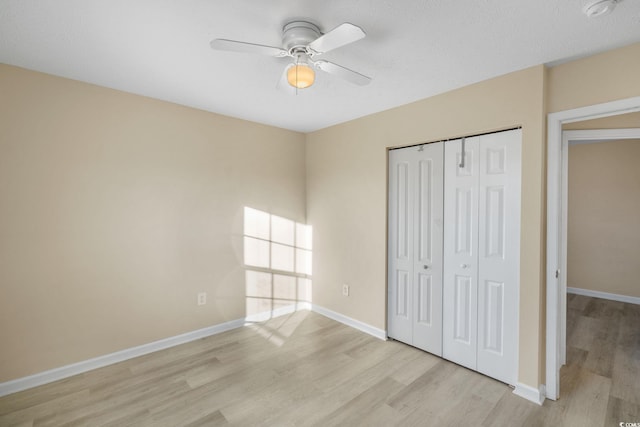 unfurnished bedroom featuring ceiling fan, light hardwood / wood-style flooring, and a closet