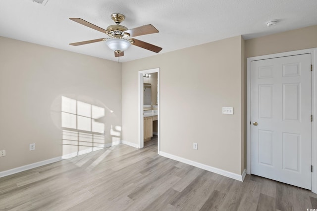 unfurnished bedroom with ensuite bath, ceiling fan, and light hardwood / wood-style floors