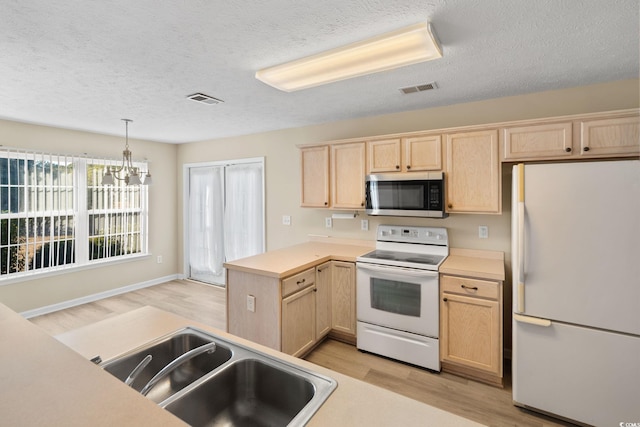 kitchen with white appliances, pendant lighting, a chandelier, light brown cabinets, and sink