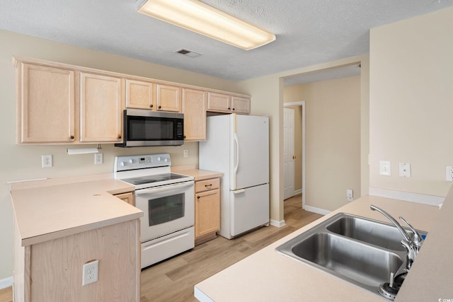 kitchen with white appliances, light hardwood / wood-style floors, light brown cabinets, a textured ceiling, and sink