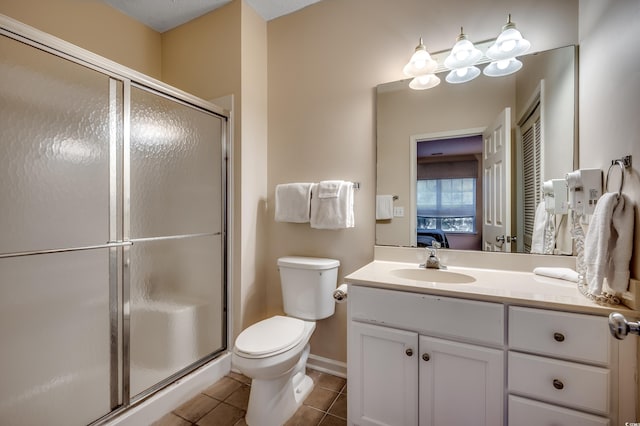 bathroom featuring toilet, tile patterned flooring, vanity, and walk in shower