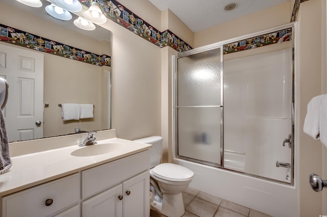 full bathroom with a textured ceiling, vanity, shower / bath combination with glass door, tile patterned flooring, and toilet