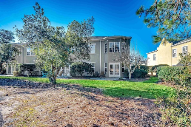 rear view of house with a yard and french doors