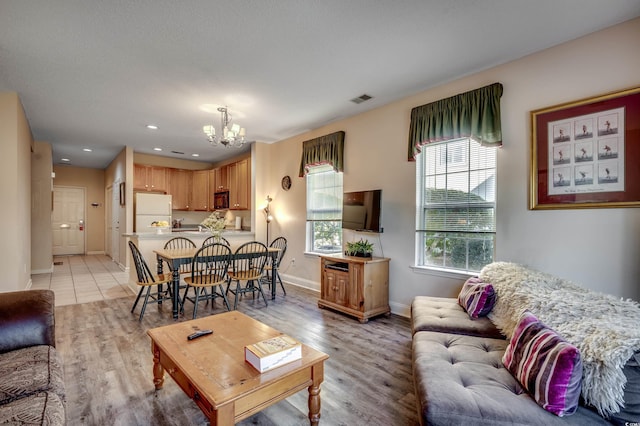 living room featuring light hardwood / wood-style floors and an inviting chandelier