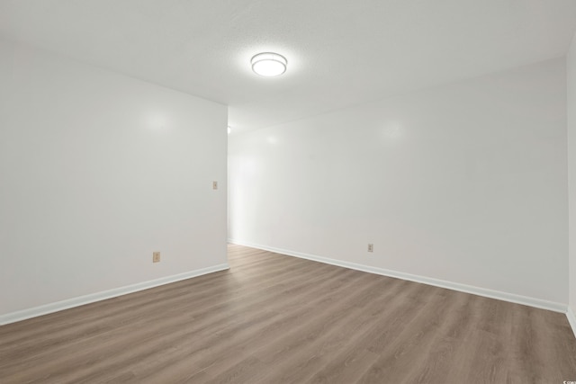 unfurnished room featuring wood-type flooring and a textured ceiling