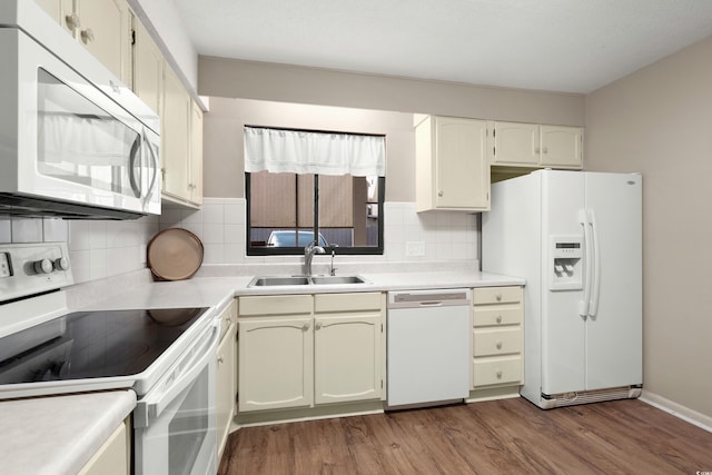 kitchen featuring tasteful backsplash, sink, white appliances, and light hardwood / wood-style floors