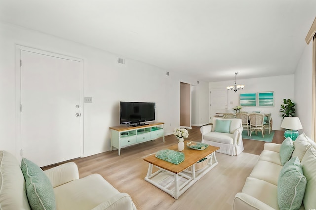 living room featuring light hardwood / wood-style flooring and a chandelier