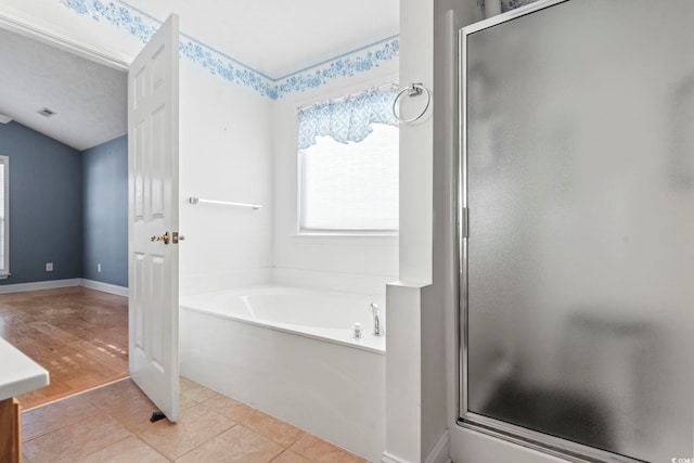 bathroom featuring lofted ceiling, separate shower and tub, and tile patterned flooring