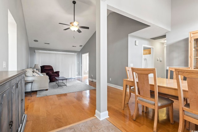 dining space featuring ceiling fan, high vaulted ceiling, and light hardwood / wood-style flooring