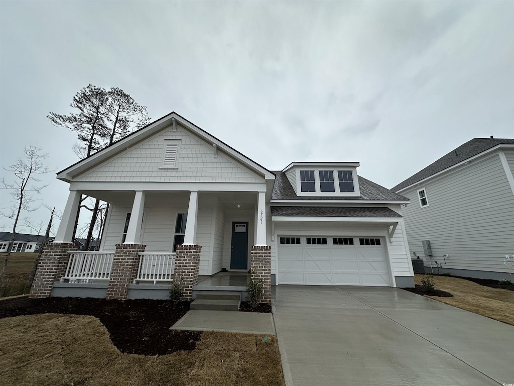 craftsman-style house featuring a front yard, a porch, and a garage