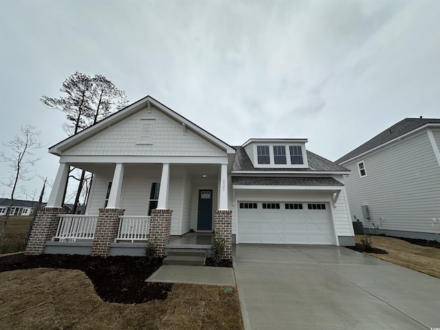 craftsman-style house featuring a front yard, a porch, and a garage