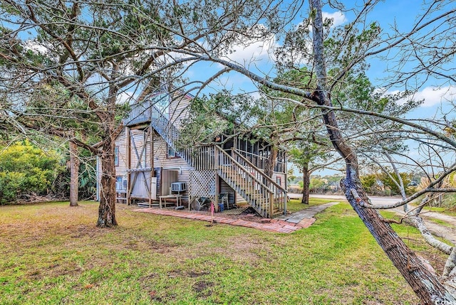 rear view of house featuring a sunroom and a yard