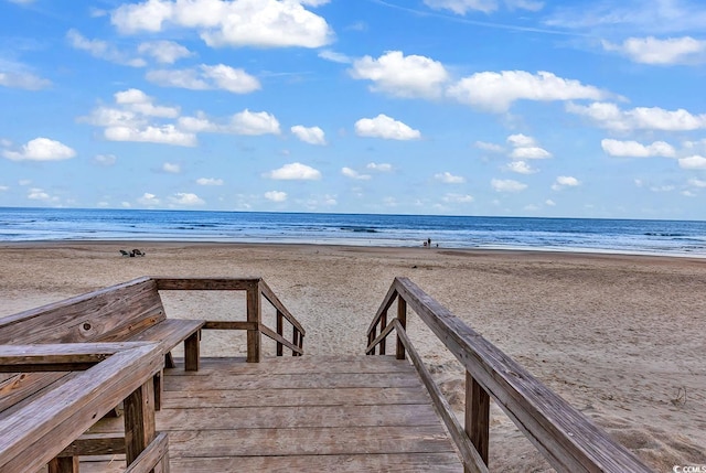 view of community featuring a beach view and a water view