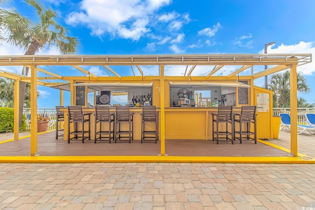 view of patio featuring exterior bar and a deck