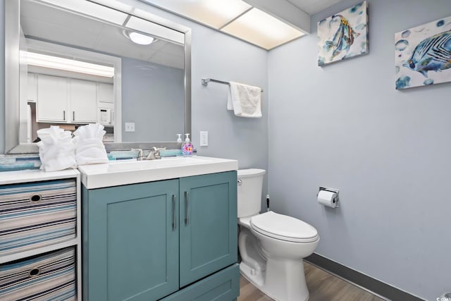 bathroom with vanity, toilet, and wood-type flooring