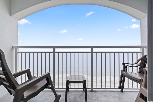 balcony with a water view and a beach view