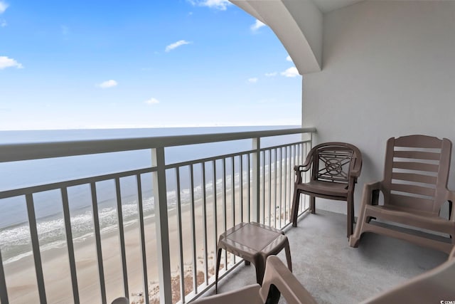 balcony featuring a water view and a view of the beach