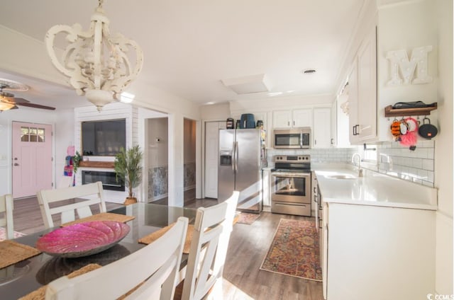 kitchen featuring white cabinets, stainless steel appliances, sink, backsplash, and dark hardwood / wood-style floors