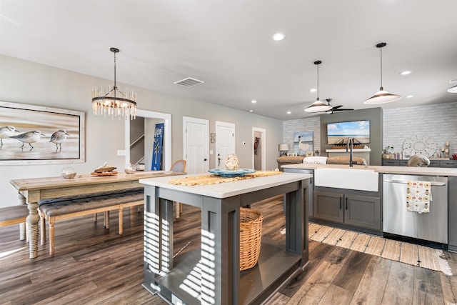 kitchen featuring pendant lighting, sink, dark wood-type flooring, and stainless steel dishwasher