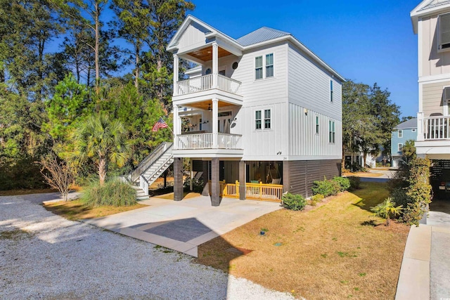 view of front of property featuring a balcony, covered porch, and a front yard