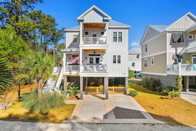 view of front of house featuring a carport, ceiling fan, a balcony, and covered porch