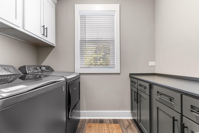 laundry area featuring separate washer and dryer, dark wood-type flooring, and cabinets