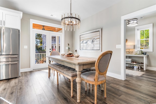 dining space with dark wood-type flooring, french doors, and a chandelier