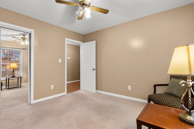 sitting room featuring ceiling fan and light colored carpet