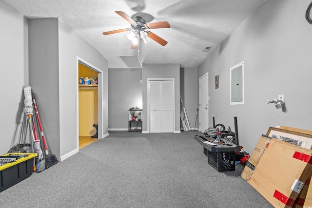 playroom featuring ceiling fan, electric panel, carpet, and a textured ceiling