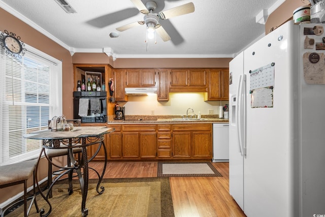 kitchen featuring crown molding, black appliances, a textured ceiling, and light wood-type flooring