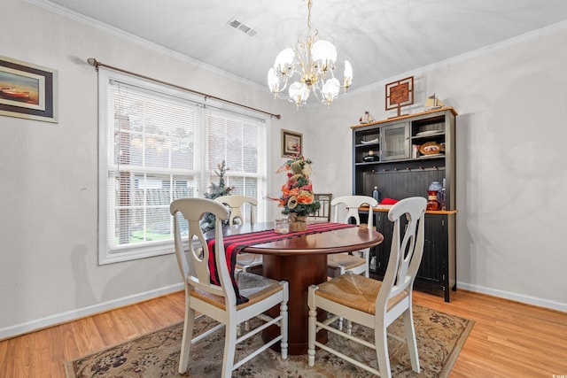 dining room with crown molding, a notable chandelier, and light hardwood / wood-style flooring