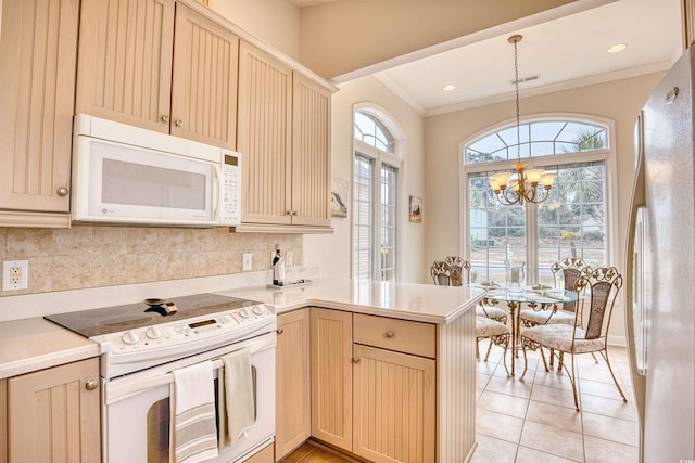 kitchen featuring kitchen peninsula, a chandelier, decorative light fixtures, white appliances, and light brown cabinetry