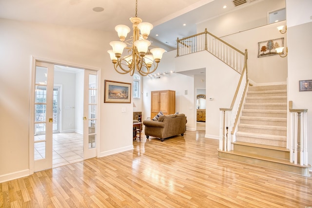 interior space featuring a notable chandelier, a high ceiling, and light hardwood / wood-style flooring